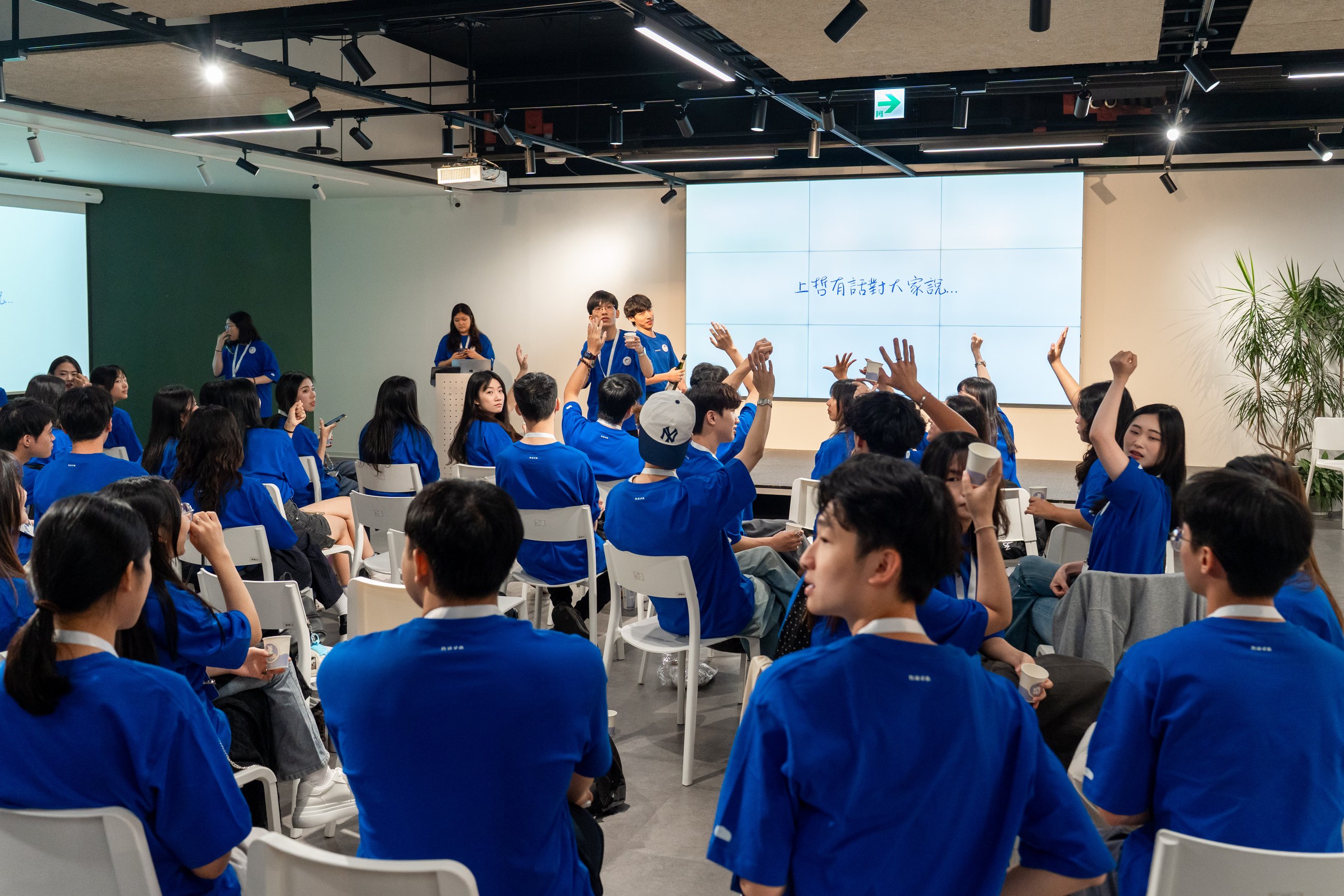 全場校園大使在舞台前舉手回應帶領者
