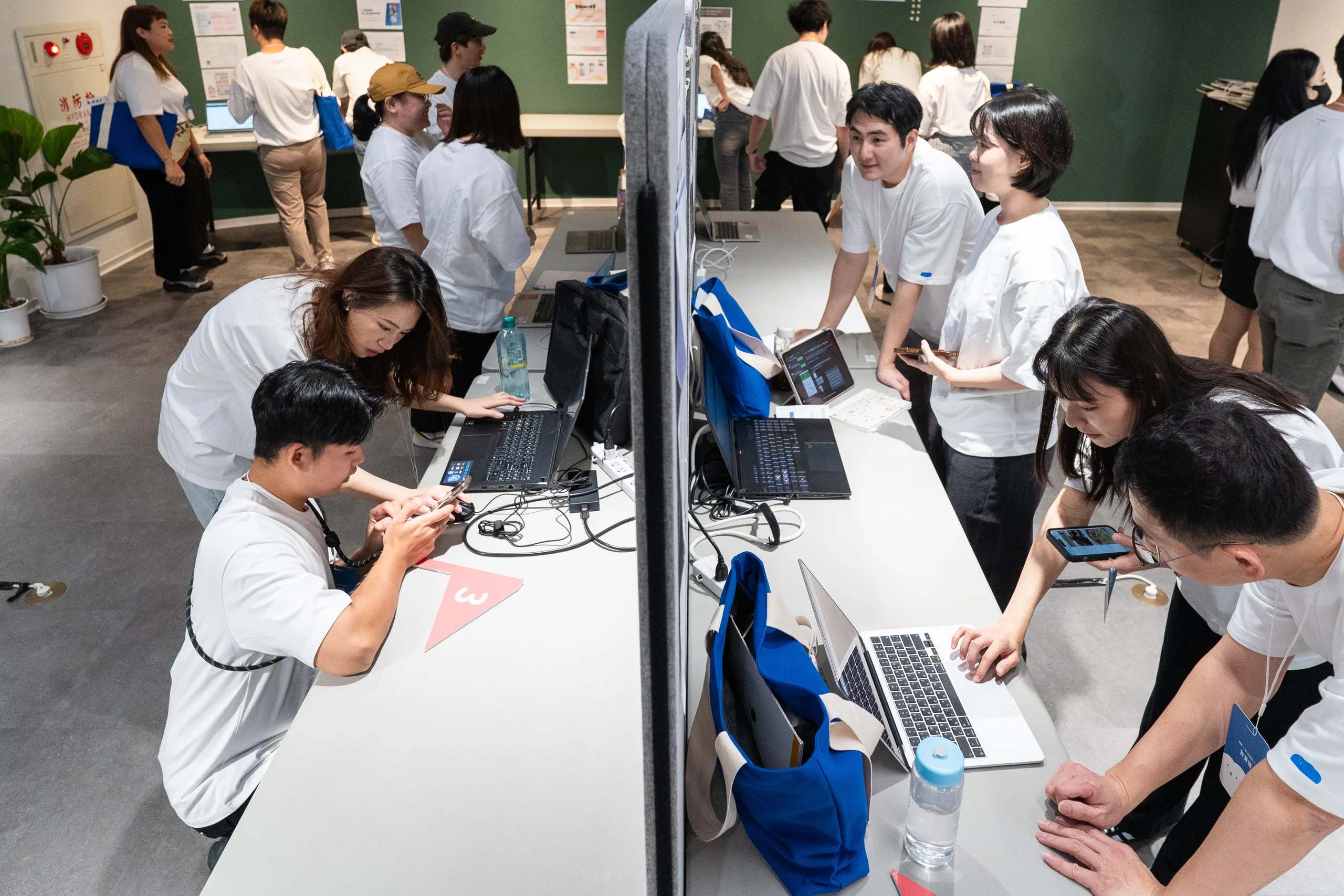 AI SAGA 2 工作團隊在展示攤位準備筆電與內容