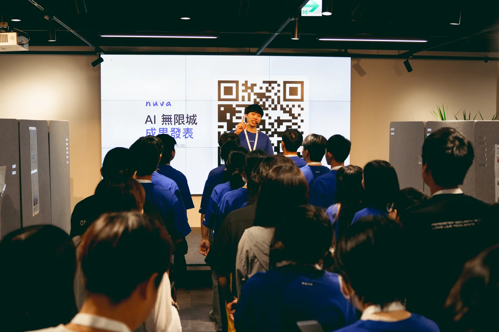 學員在成果海報前向參觀者介紹作品